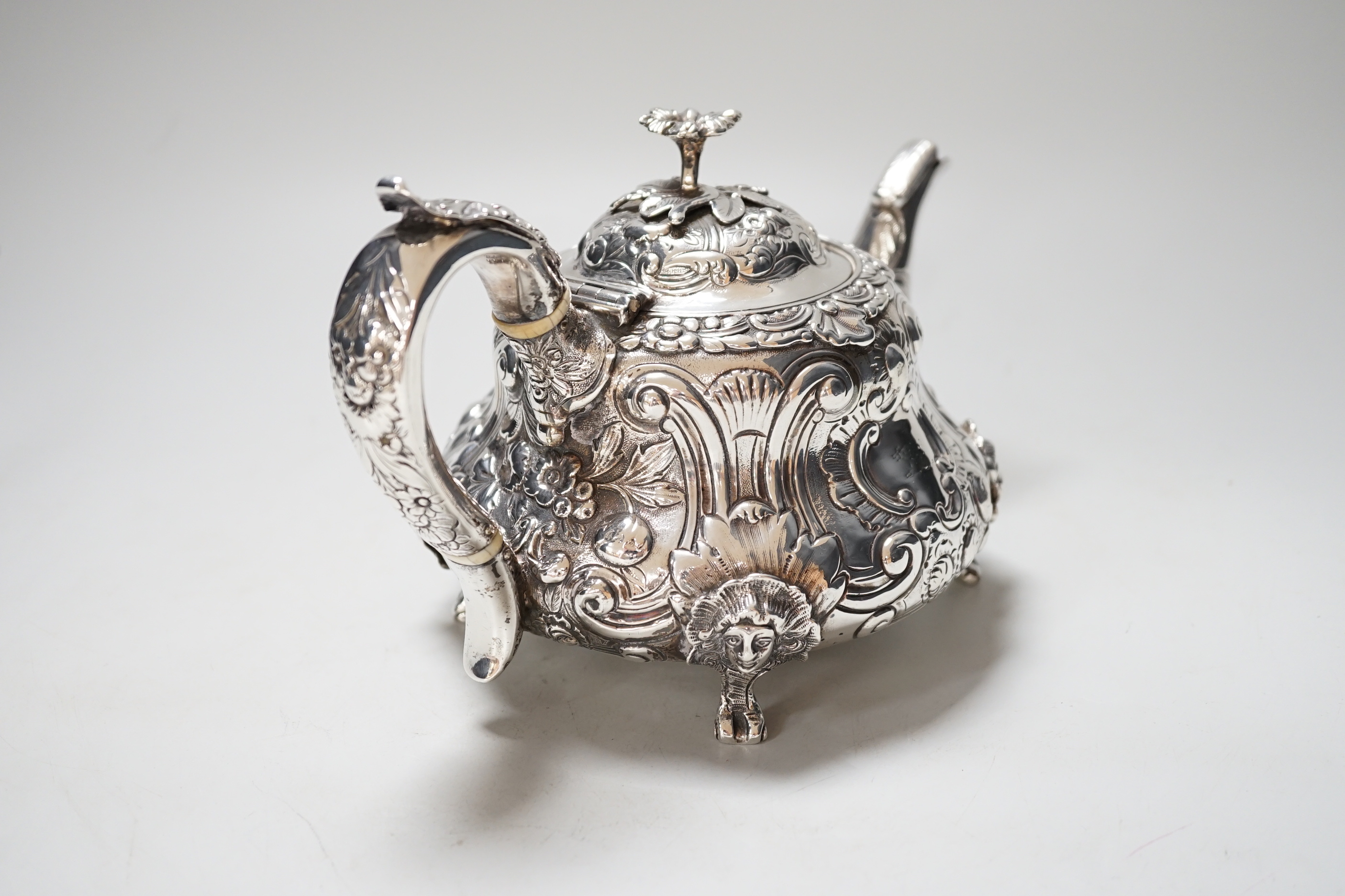 A William IV silver teapot, with floral knop, scroll and mask decoration, makers mark rubbed, London 1831, gross 617 grams, CITIES Submission reference NX44TQHA